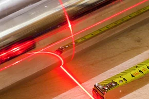 Aufmass vor Ort - Messkonzept mit Maßbandwerkzeug und rotem Laserstrahl, ausmessen