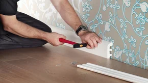 Fussleisten - Decor-Union Service 044 Handwerker montiert/nagelt Fußleisten auf tapezierte Wand