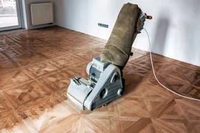 Schleifen von Parkett, Tafelboden mit der Schleifmaschine. - Schleifen von Parkett, Tafelboden mit der Schleifmaschine.