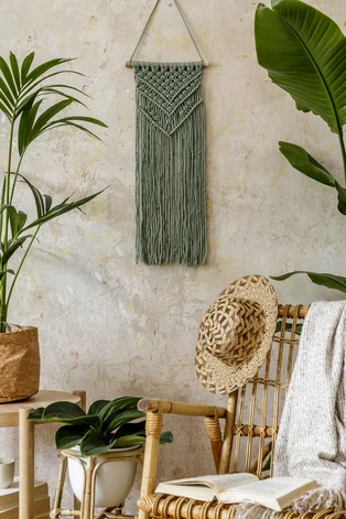 Illustration - Ihr Experte für schönes Wohnen - Stilvolle und florale Zusammensetzung des Wohnzimmers Interieur mit Rattan Sessel, viele tropische Pflanzen in Design-Töpfe, Dekoration, Makramee und elegante persönliche Accessoires in gemütlicher Wohnkultur.